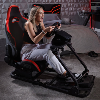 Woman using a gaming simulator chair in a room with a geometric wall design.