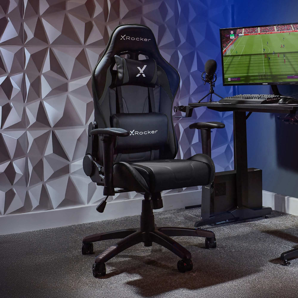 Gaming chair with X rocker logo in a room setup with a computer monitor and desk.