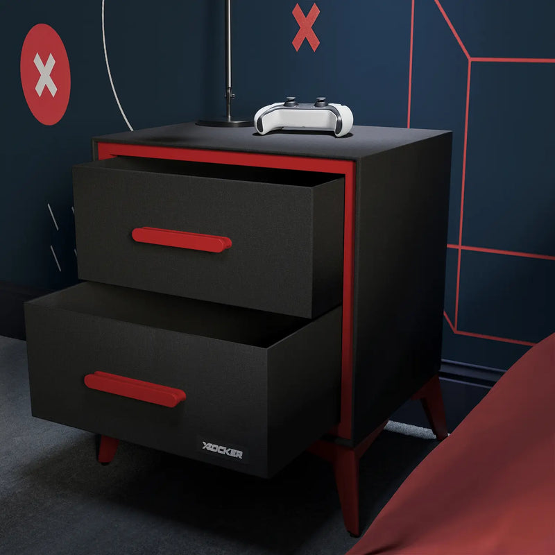 Black and red drawer unit with 'X Rocker' branding against a dark wall with geometric patterns.