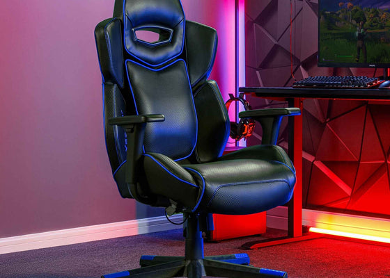 Gaming chair in a room with red and purple lighting, featuring a computer setup.