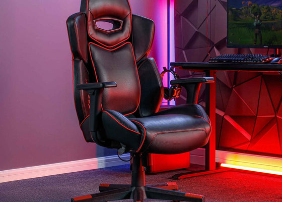 Gaming chair in a room with red lighting and a computer setup.