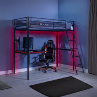 Gaming room setup with a loft bed, desk, and chair in a dimly lit room.