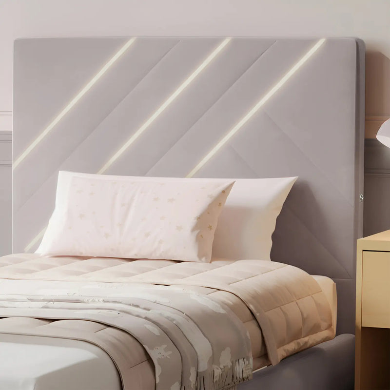 Gray upholstered headboard with LED lights and bedding on a bed.