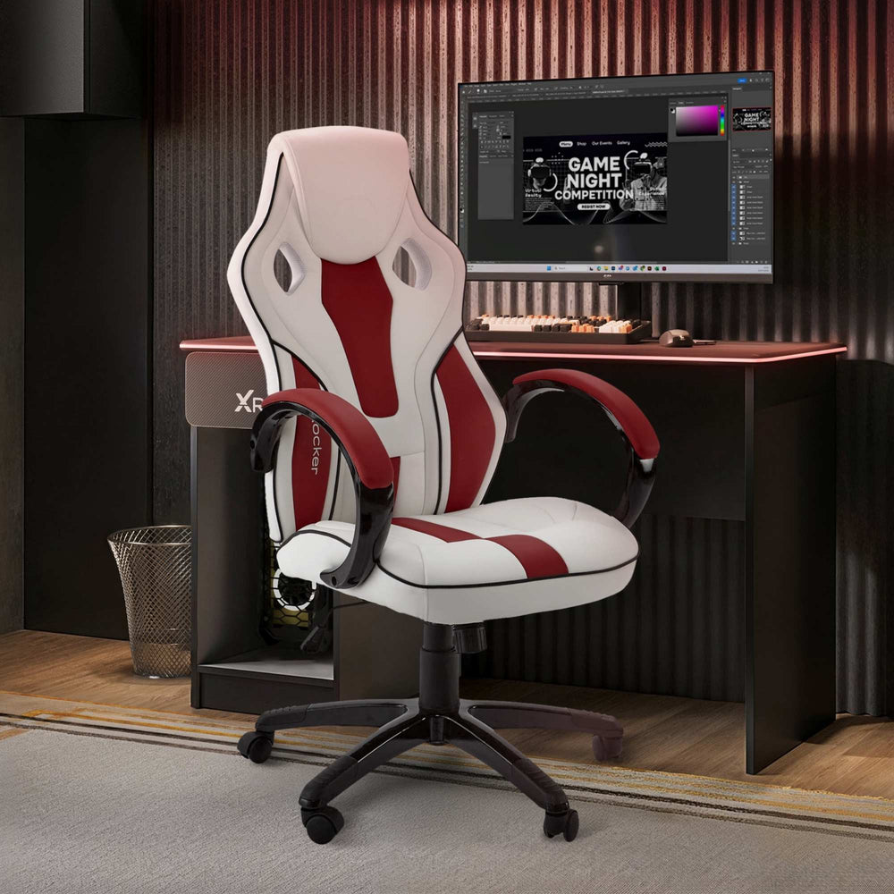 Gaming chair with red and white design in front of a computer desk with a monitor.