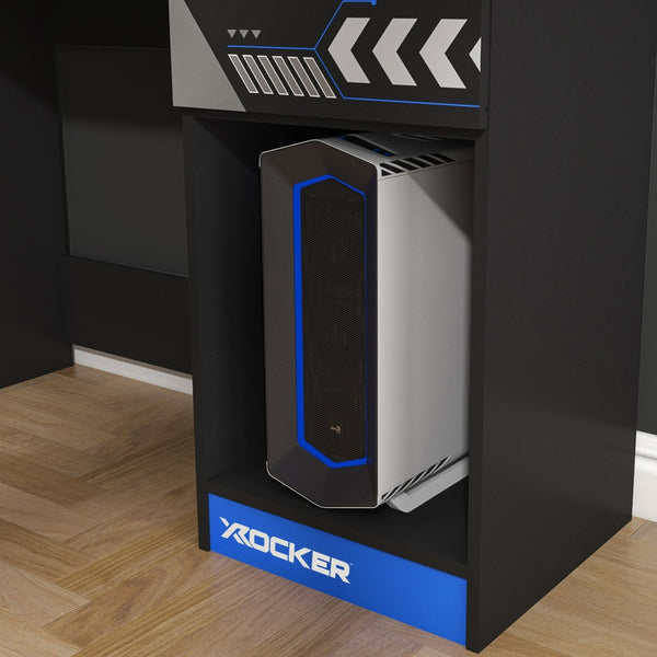 Computer tower on a black stand with 'X rocker' branding in a room setting.