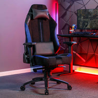 Gaming chair in a room with red lighting and a desk setup.