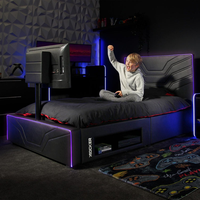 Child sitting on a gaming bed with LED lighting in a dark room