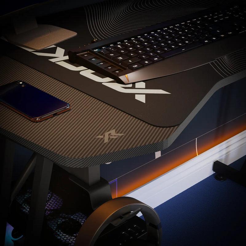Gaming desk setup with mouse pad, keyboard, and phone on a dark surface