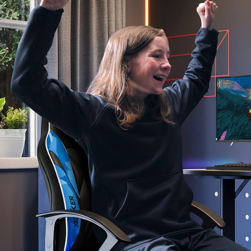 Person sitting in a gaming chair with arms raised in an gaming setting