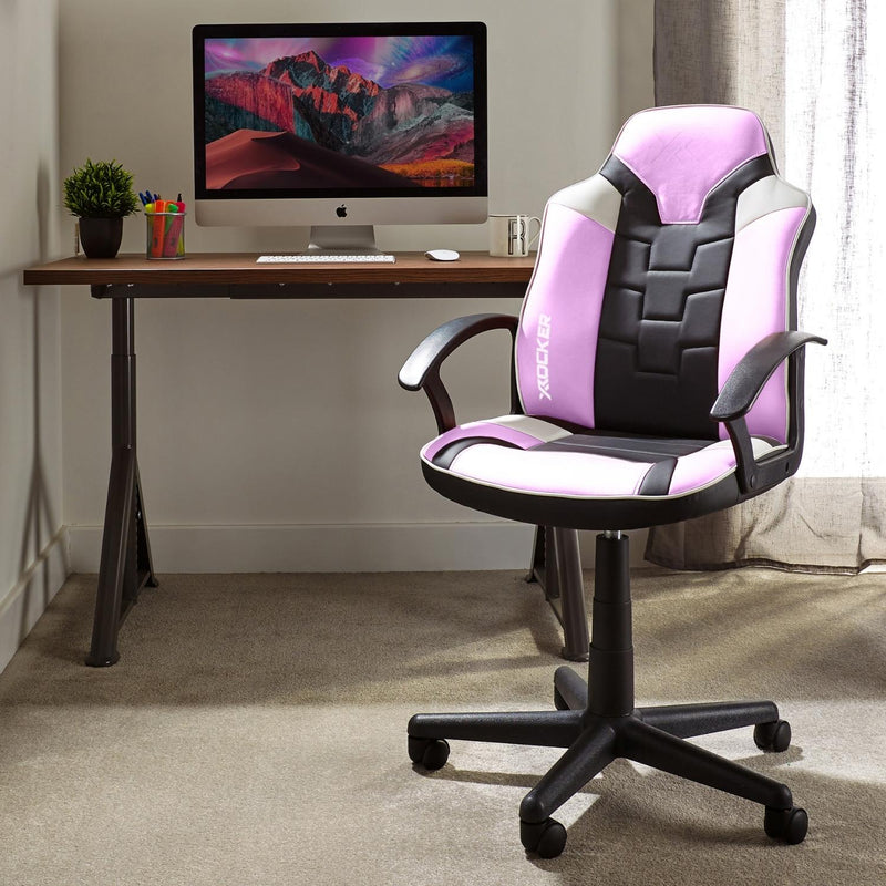 Gaming chair with pink and black design in front of a computer desk.