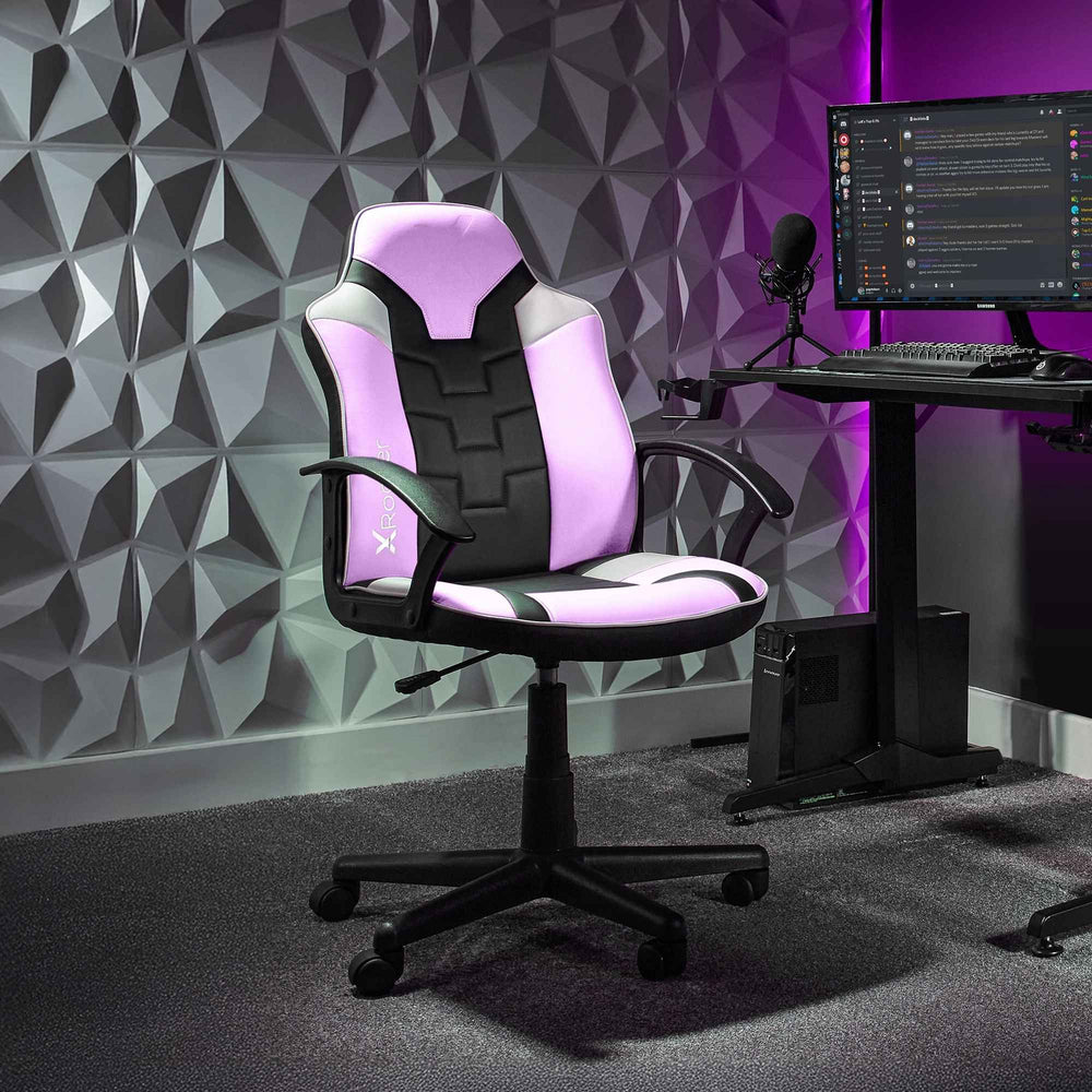 Gaming chair in a room with a geometric wall design and computer setup.