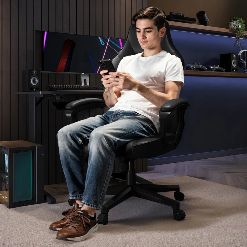 man sitting in a gaming chair using a smartphone in a home office setup.
