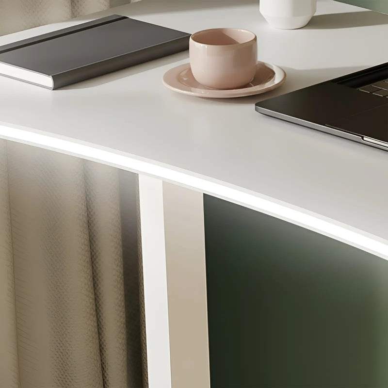 White desk with a pink cup, plate, and laptop on a neutral background