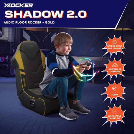 X rocker Shadow 2.0 gaming chair for juniors with a child sitting on it, set against a dark background.