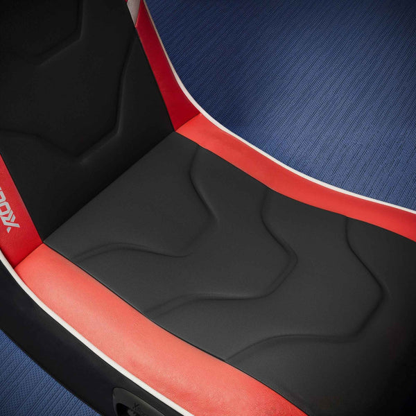Close-up of a gaming chair seat with red and black design on a blue textured background