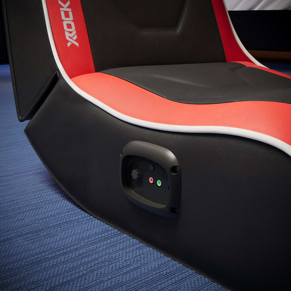 Close-up of a gaming chair with red and black design on a blue carpet