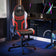 X Rocker Agility Compact Gaming chair with red and black design in a room with a desk and computer setup.