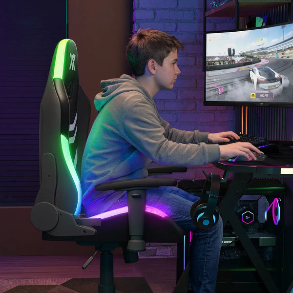 Person playing a racing game on a computer in a room with gaming chair and setup.
