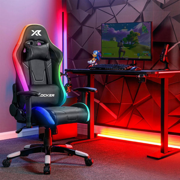 Gaming setup with a chair, desk, and computer monitor in a room with geometric wall design.