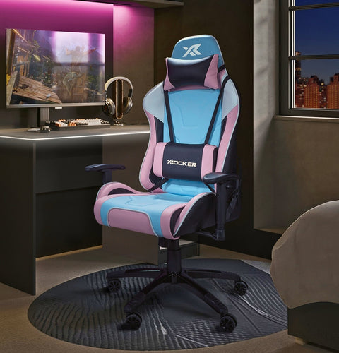 Gaming chair with pink and blue accents in a room with a desk and computer setup.