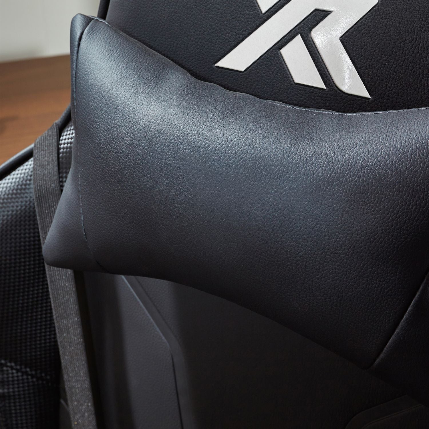 Close-up of a black cushion with a X Rocker logo on the surface