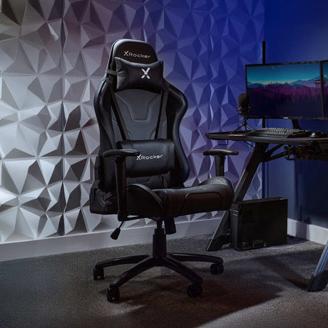 X-Rocker gaming chair in a room with geometric wall design and computer setup.