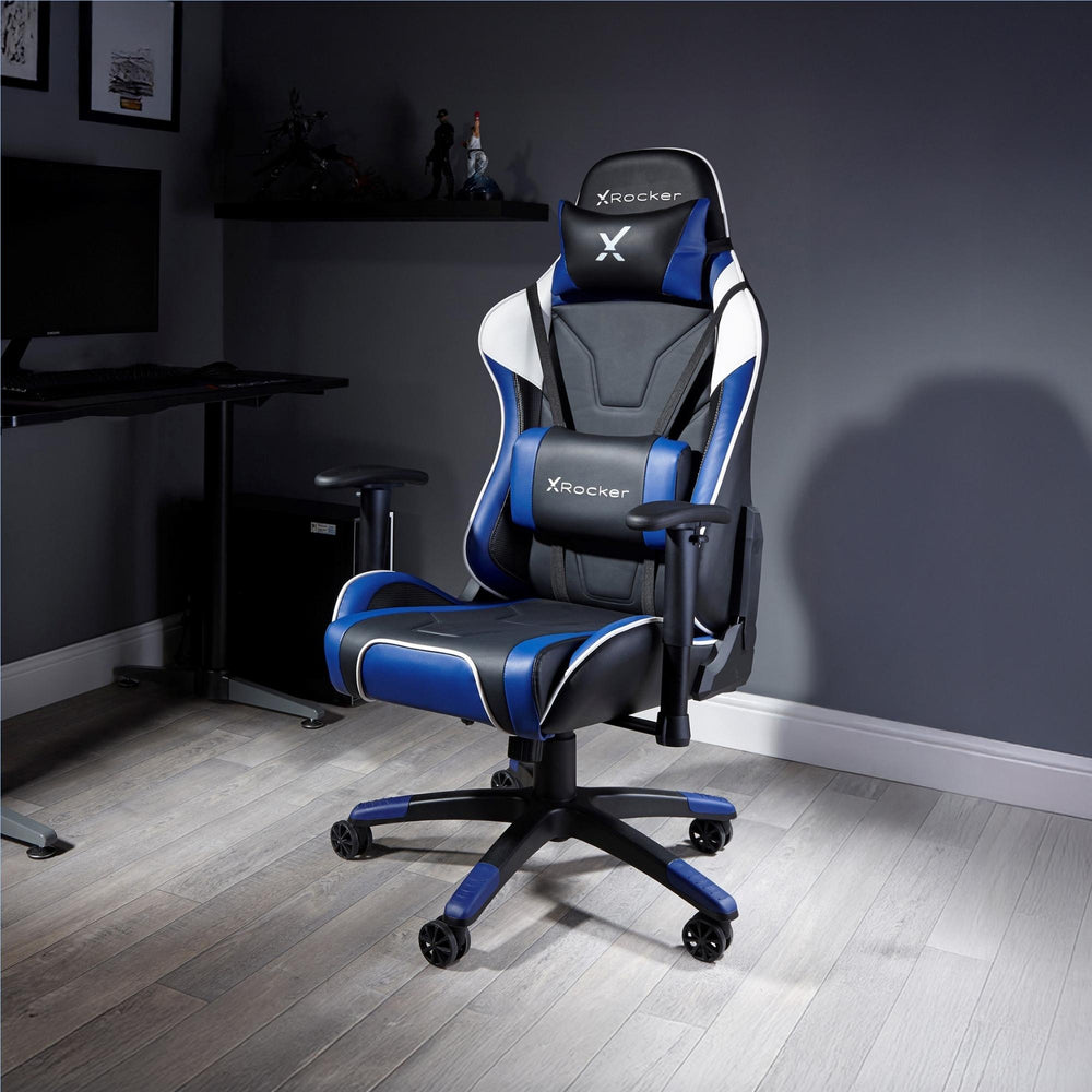 X rocker gaming chair in a room with a desk and computer setup.