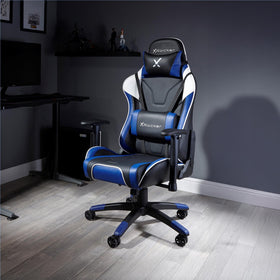 X rocker gaming chair in a room with a desk and computer setup.