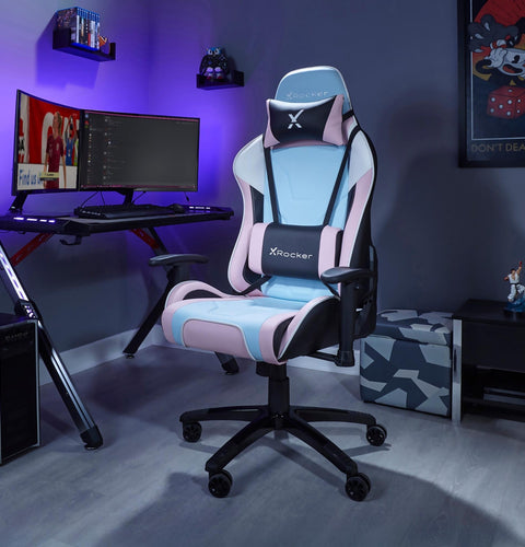 Gaming chair with X rocker logo in a room setup with a desk and computer monitors.