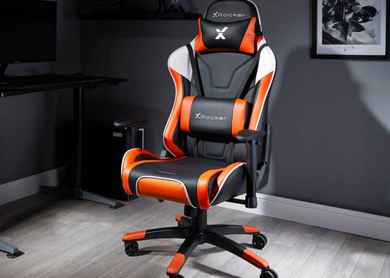 Black and orange gaming chair with X rocker logo in a room setting.