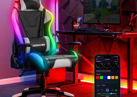 Gaming chair with RGB lighting in a room setup with a computer desk and smartphone app.