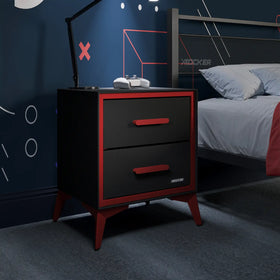 Black and red nightstand next to a bed with gaming equipment in a bedroom setting.