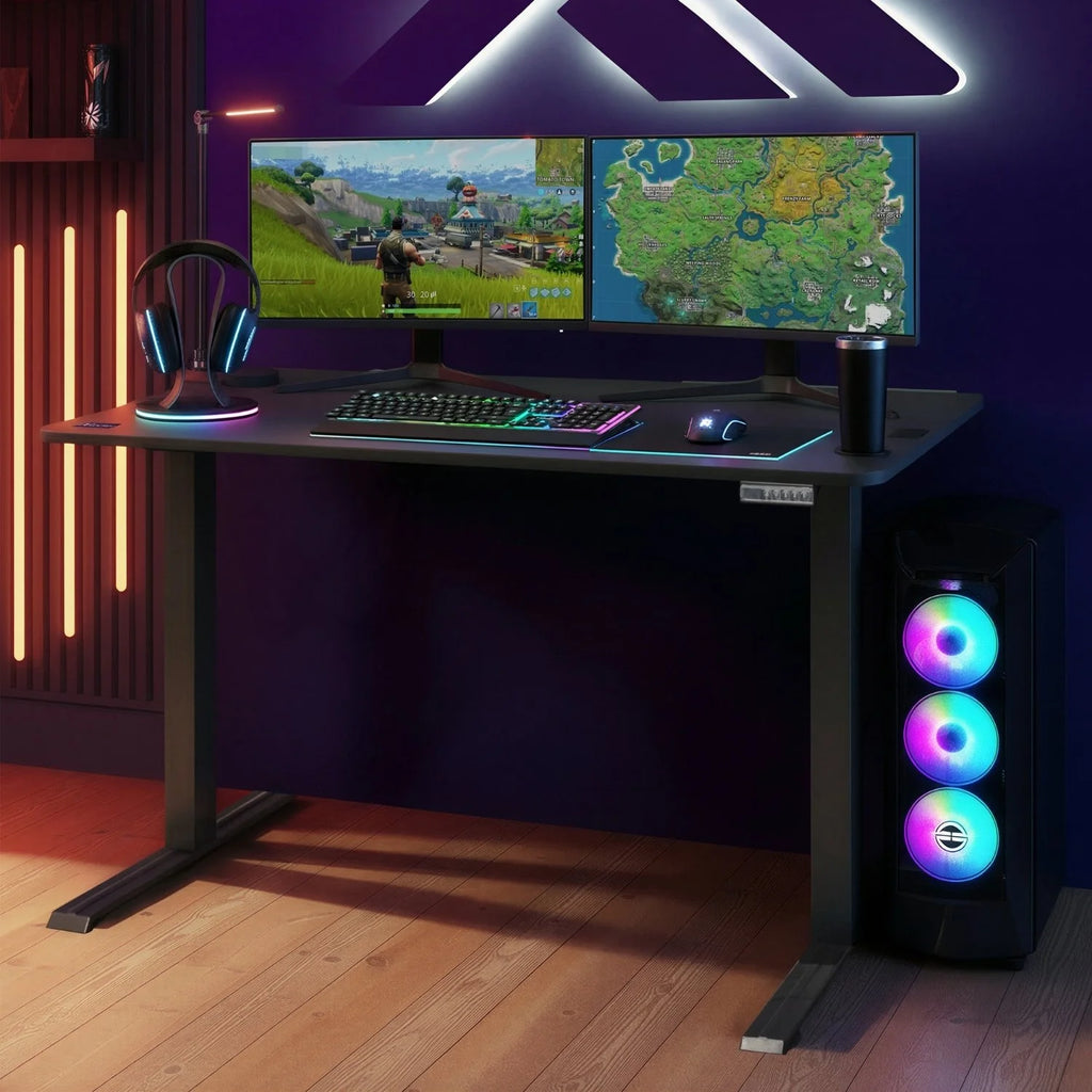 Gaming setup with dual monitors, keyboard, mouse, and RGB lighting on a height adjustable black desk.