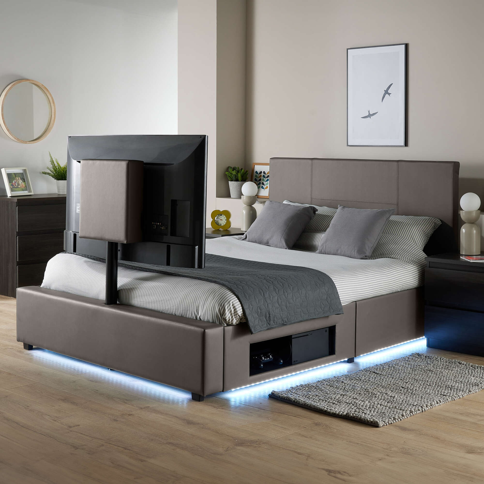 Modern bed with TV above in a bedroom setting