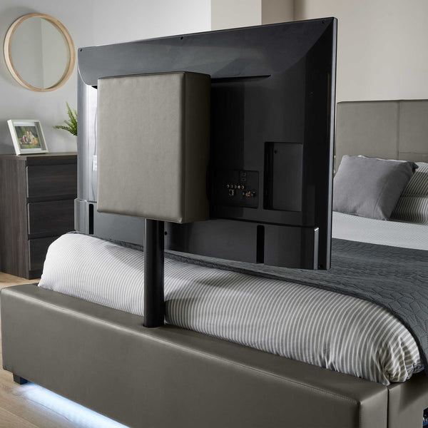 Black TV mounted on a bed frame in a bedroom.