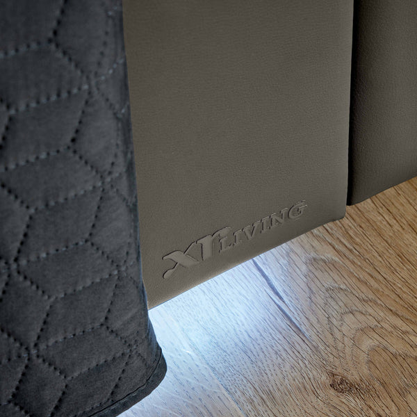 Close-up of a brown mat with 'XR Living' branding on a wooden floor.