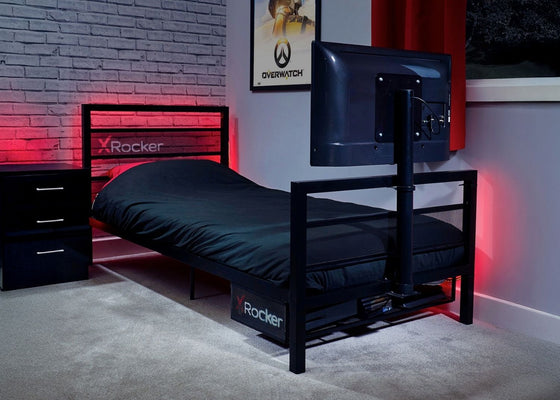 Bedroom with X-Rocker bed frame, gaming setup, and Overwatch poster.