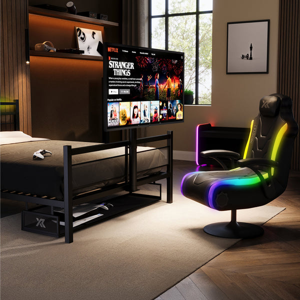 Modern bedroom with a bed, TV displaying 'Stranger Things', and a colorful gaming chair.