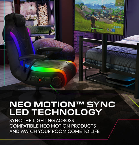 Gaming chair with Neo Motion Sync LED technology in a room setup with a TV and gaming console.