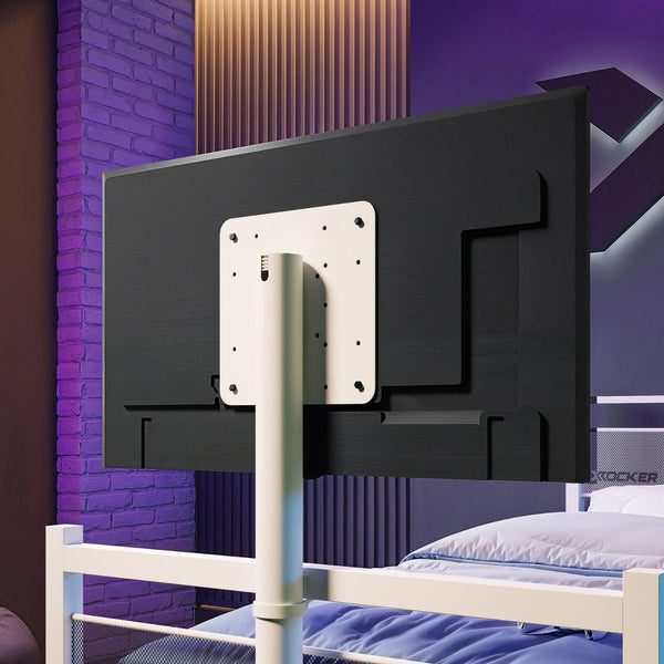 Black TV mount against a purple brick wall with a bed in the foreground