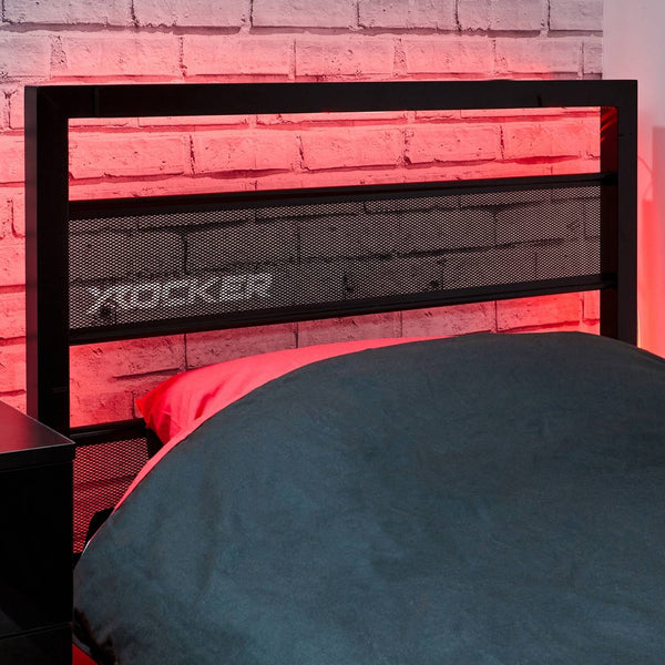 Black metal headboard with 'X rocker' branding against a brick wall with red lighting.
