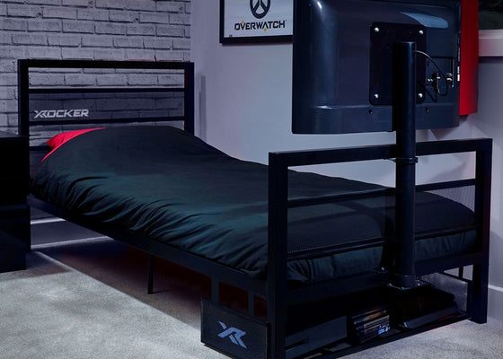 Bedroom setup with a bed, TV stand, and gaming-themed decor.