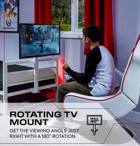Person playing video games on a rotating TV mount in a room with red curtains.