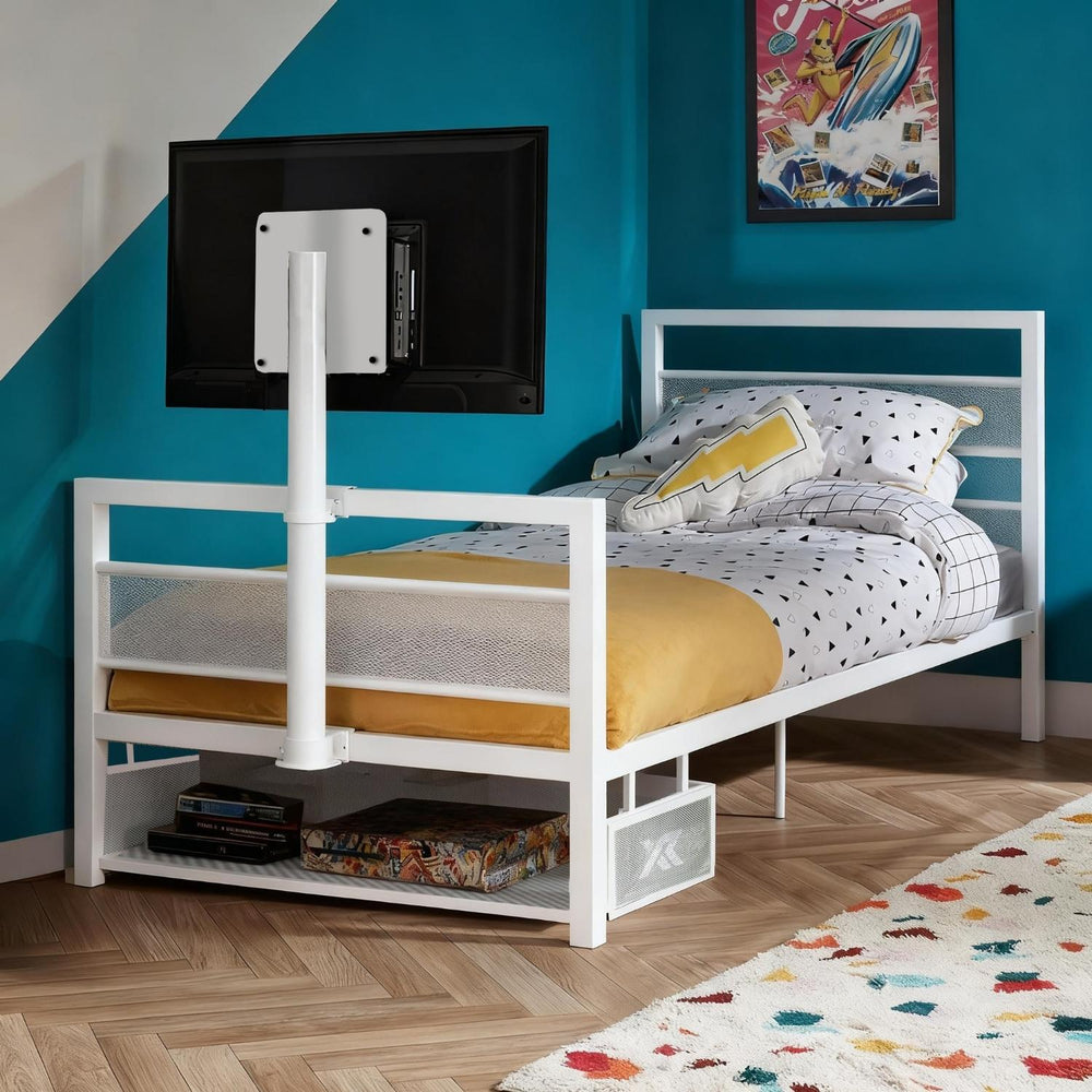 White metal bed with yellow mattress against a blue wall with a TV mounted on it.