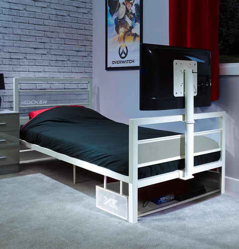 White tv bed with black mattress in a room with a TV and gaming posters.