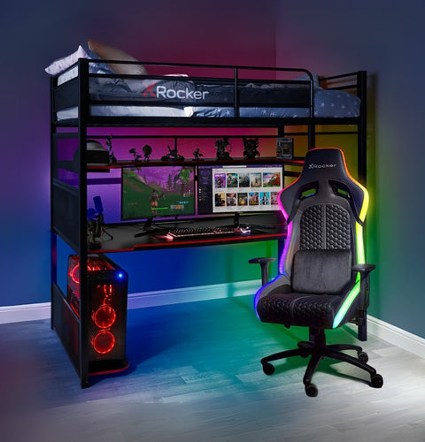Gaming room setup with a desk, chair, and computer equipment in a room with colorful lighting.
