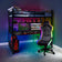 Gaming room setup with a desk, chair, and computer equipment in a room with colorful lighting.
