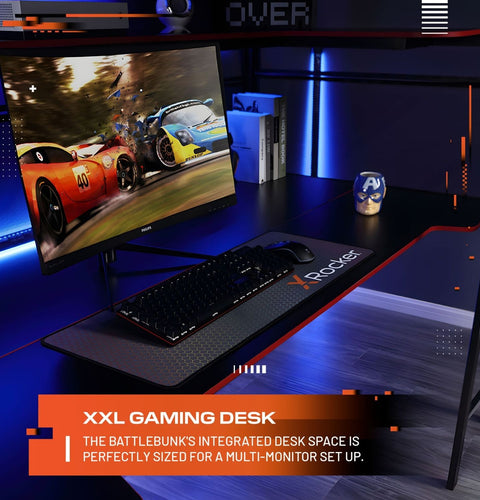 Gaming desk setup with monitor, keyboard, and mouse on a dark surface with blue lighting.