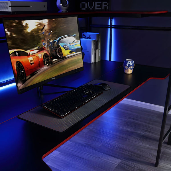 Gaming desk setup with monitor, keyboard, and mouse on a dark surface.