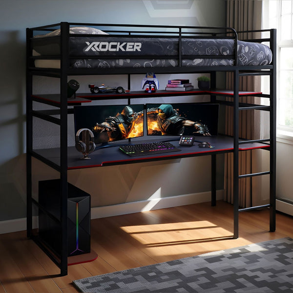 Black X rocker gaming desk with two monitors, keyboard, and mouse in a room.